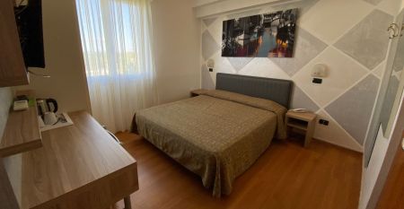 Außenansicht des Hotel RIZ mit Pool, Liegestühlen und spielenden Kindern.