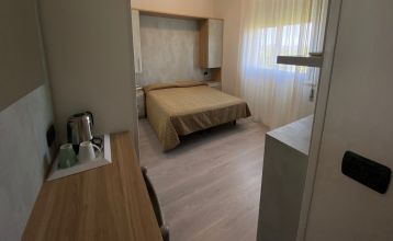 Außenansicht des Hotel RIZ mit Pool, Liegestühlen und spielenden Kindern.