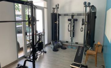 Außenansicht des Hotel RIZ mit Pool, Liegestühlen und spielenden Kindern.