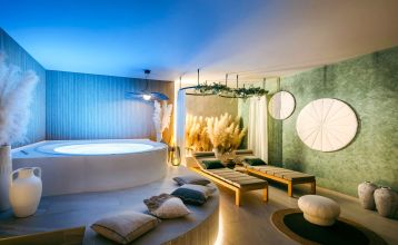 Luftaufnahme des Valamar Padova Hotels 4* – eines Resorts an der Küste mit Pool, Sonnenliegen, Strohsonnenschirmen, Palmen und direktem Zugang zu einem Sandstrand in der Nähe einer historischen Küstenstadt bei Sonnenuntergang. Die Gäste können vielfältige