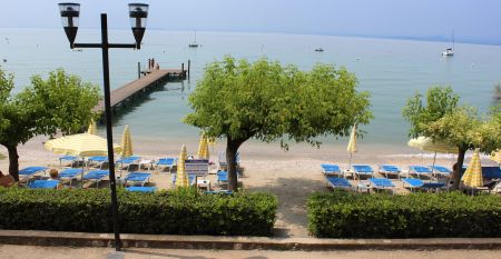 Gartenrestaurant des Hotel Sportsman mit Rattanm&ouml;beln, Sonnenschirmen und gedeckten Tischen auf gepflegtem Rasen.