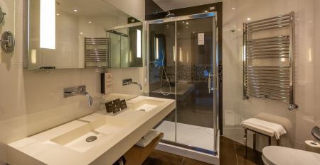 Luftaufnahme der &uuml;ppigen Fairways, Sandbunker, Wasserhindernisse und des markanten Clubhauses mit sechseckigem Dach des Albarella Golf Hotels &ndash; ideal zur Erholung und f&uuml;r eine ruhige Atmosph&auml;re nach dem Sport.