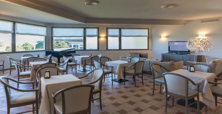 Luftaufnahme der &uuml;ppigen Fairways, Sandbunker, Wasserhindernisse und des markanten Clubhauses mit sechseckigem Dach des Albarella Golf Hotels &ndash; ideal zur Erholung und f&uuml;r eine ruhige Atmosph&auml;re nach dem Sport.