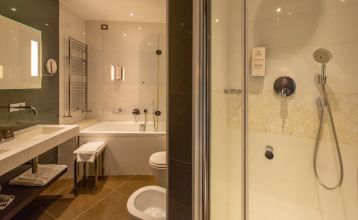 Luftaufnahme der üppigen Fairways, Sandbunker, Wasserhindernisse und des markanten Clubhauses mit sechseckigem Dach des Albarella Golf Hotels – ideal zur Erholung und für eine ruhige Atmosphäre nach dem Sport.
