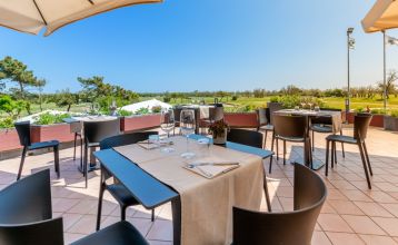Luftaufnahme der üppigen Fairways, Sandbunker, Wasserhindernisse und des markanten Clubhauses mit sechseckigem Dach des Albarella Golf Hotels – ideal zur Erholung und für eine ruhige Atmosphäre nach dem Sport.