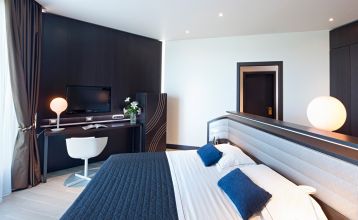 Luftaufnahme der üppigen Fairways, Sandbunker, Wasserhindernisse und des markanten Clubhauses mit sechseckigem Dach des Albarella Golf Hotels – ideal zur Erholung und für eine ruhige Atmosphäre nach dem Sport.