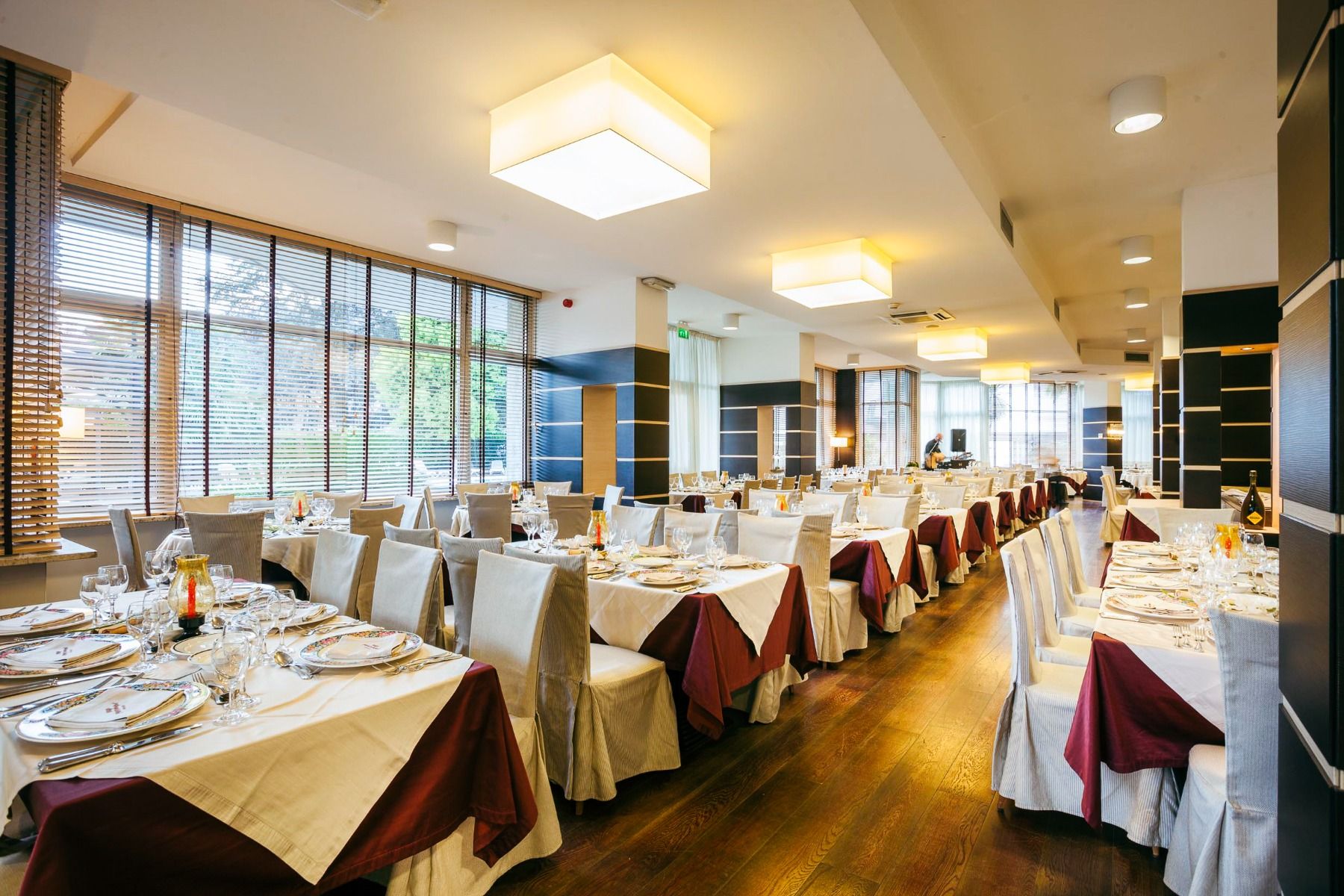 Elegantes Hotelrestaurant mit gedeckten Tischen, großen Fenstern und moderner Einrichtung.