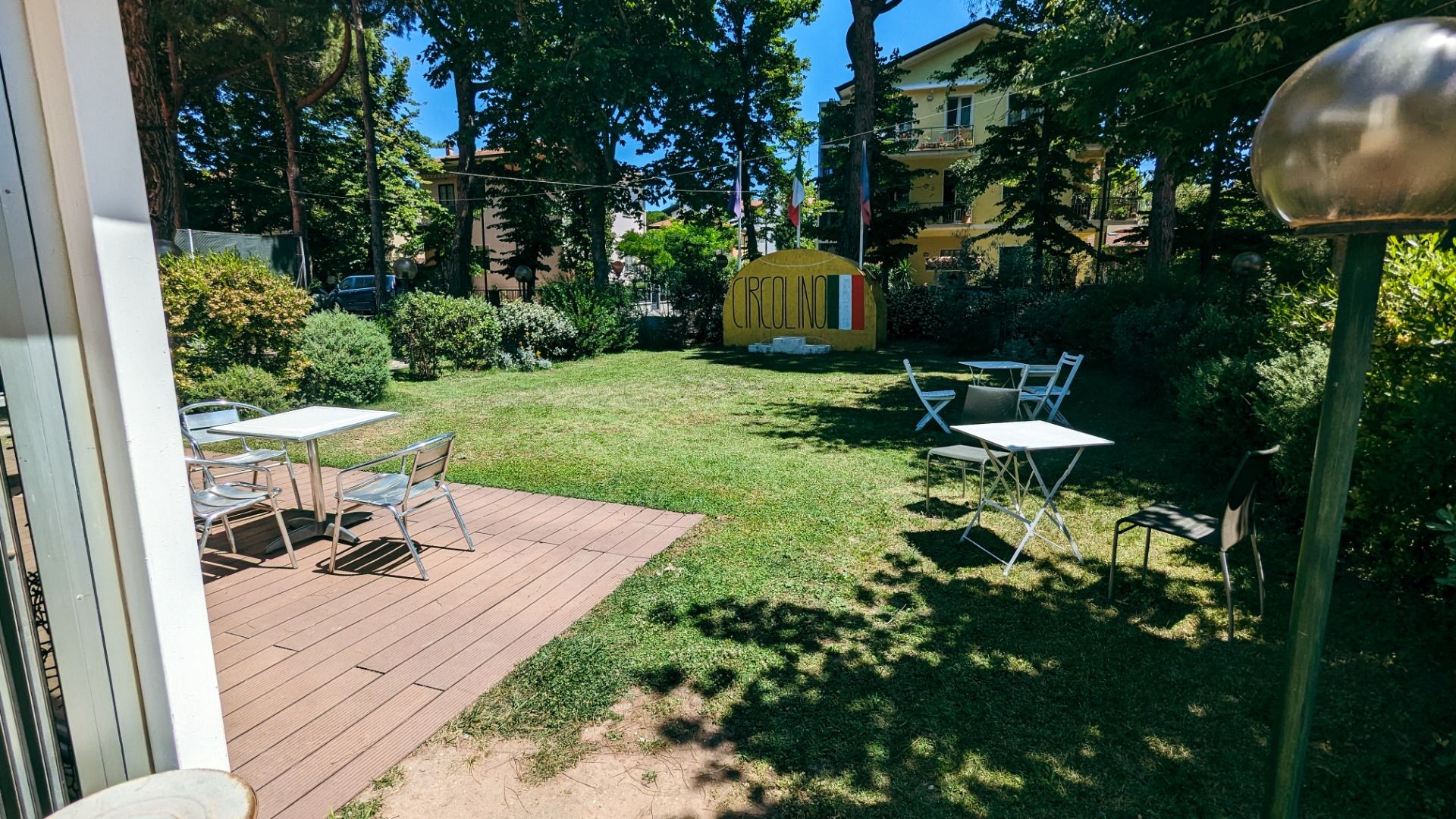Gartenbereich mit Sitzgelegenheiten und einem Schild mit der Aufschrift „Circolino.“ 