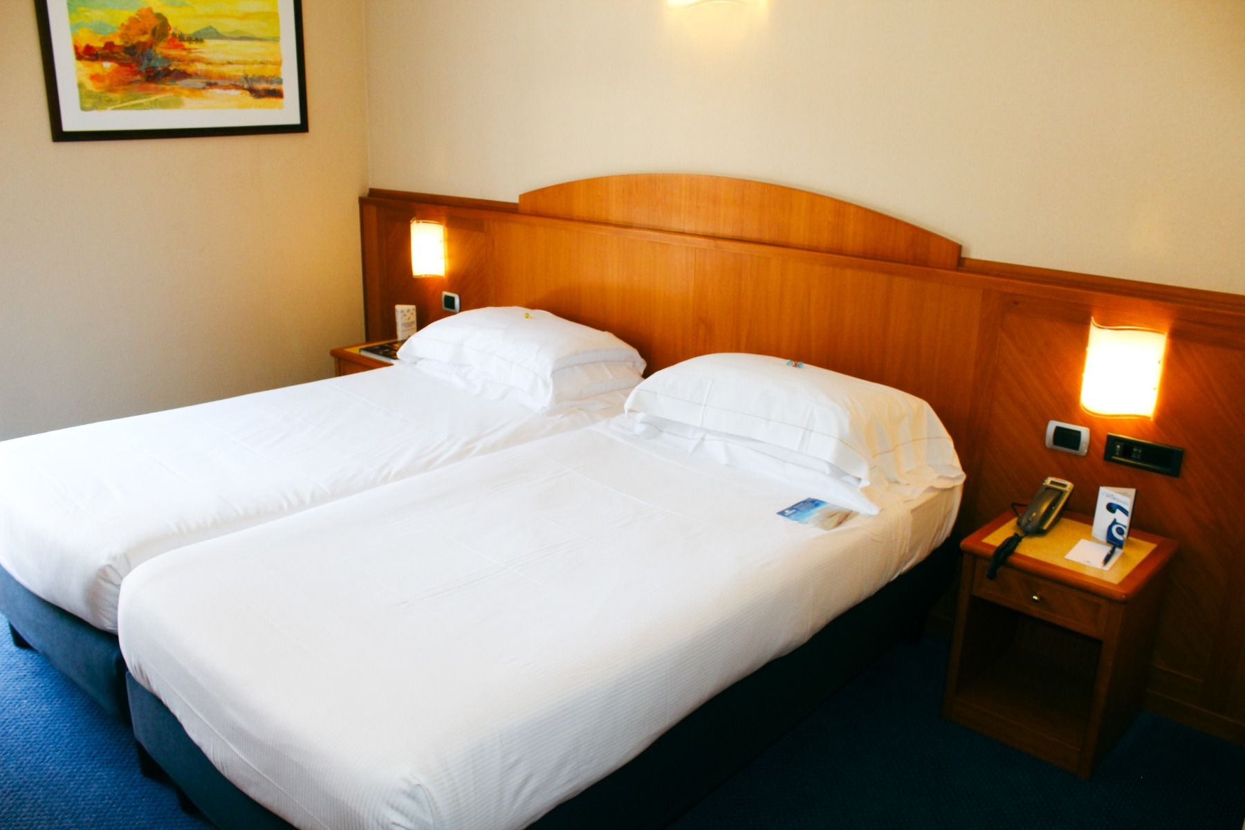 Doppelzimmer im Hotel Sportsman mit einem Doppelbett, Holzmöbeln und weißer Bettwäsche.