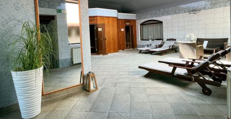 Luftaufnahme der mediterranen Stadt mit dem Hotel Villa Letan, das f&uuml;r seinen Wert bekannt ist und rote Ziegeld&auml;cher, einen Pool, einen Sportplatz und &uuml;ppiges Gr&uuml;n unter einem klaren blauen Himmel aufweist.