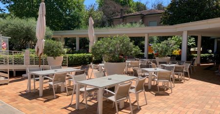 Außenansicht des Hotel RIZ mit Pool, Liegestühlen und spielenden Kindern.