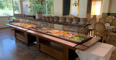 Außenansicht des Hotel RIZ mit Pool, Liegestühlen und spielenden Kindern.