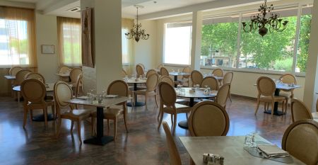 Außenansicht des Hotel RIZ mit Pool, Liegestühlen und spielenden Kindern.