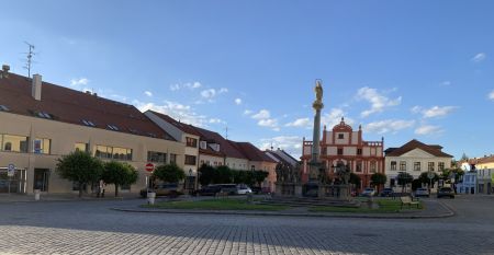 Das Hotel Biograf besticht durch eine hellgelbe und pfirsichfarbene Fassade, auff&auml;llige Beschilderungen f&uuml;r das Hotel, das Restaurant und das Caf&eacute; sowie Fenster auf beiden Etagen; links ist ein blaues Stra&szlig;enschild zu sehen.