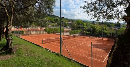 Eingang des Sporthotels Olimpo mit Steinfassade, Hotelname und Sternenmarkierung, umgeben von Pflanzen und B&auml;umen.