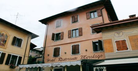 Außenansicht des Hotels mit traditioneller Fassade, Holzfensterläden und Restaurant-Markise.