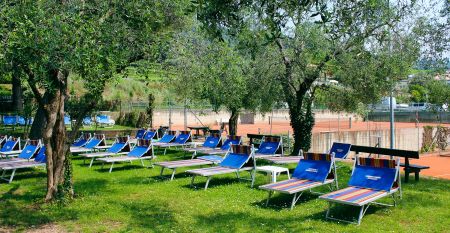 Eingang des Sporthotels Olimpo mit Steinfassade, Hotelname und Sternenmarkierung, umgeben von Pflanzen und B&auml;umen.
