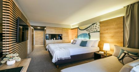Luftaufnahme des Valamar Padova Hotels 4* – eines Resorts an der Küste mit Pool, Sonnenliegen, Strohsonnenschirmen, Palmen und direktem Zugang zu einem Sandstrand in der Nähe einer historischen Küstenstadt bei Sonnenuntergang. Die Gäste können vielfältige