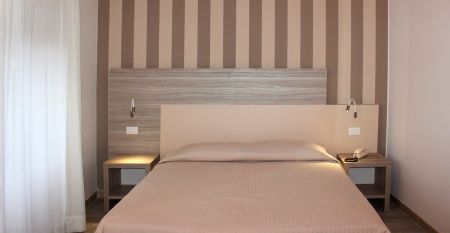 Außenansicht des Hotels mit traditioneller Fassade, Holzfensterläden und Restaurant-Markise.