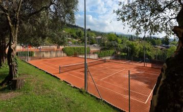 Eingang des Sporthotels Olimpo mit Steinfassade, Hotelname und Sternenmarkierung, umgeben von Pflanzen und Bäumen.