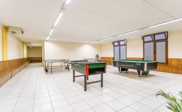 Außenansicht der Hotelanlage La Pertica mit Pool, Sonnenschirmen und Garten, eingebettet in eine Berglandschaft.