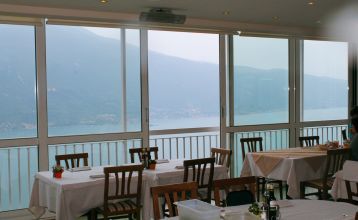 Außenansicht des Hotels mit traditioneller Fassade, Holzfensterläden und Restaurant-Markise.
