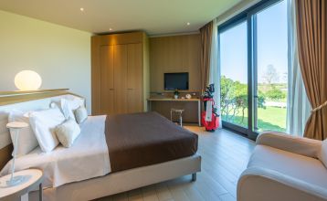 Luftaufnahme der üppigen Fairways, Sandbunker, Wasserhindernisse und des markanten Clubhauses mit sechseckigem Dach des Albarella Golf Hotels – ideal zur Erholung und für eine ruhige Atmosphäre nach dem Sport.